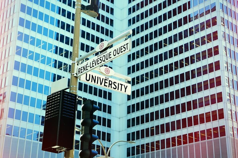 road signs on a traffic light near a building