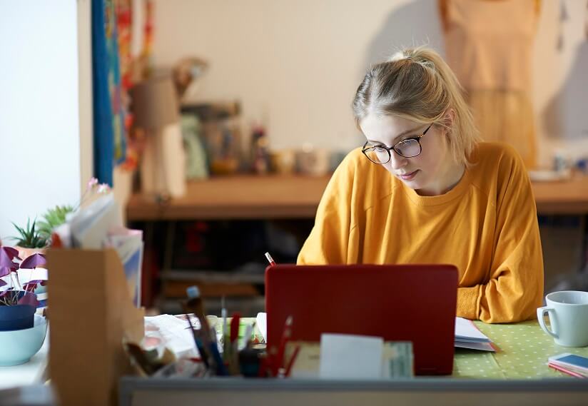 femme assise à son bureau et regardant son ordinateur portable