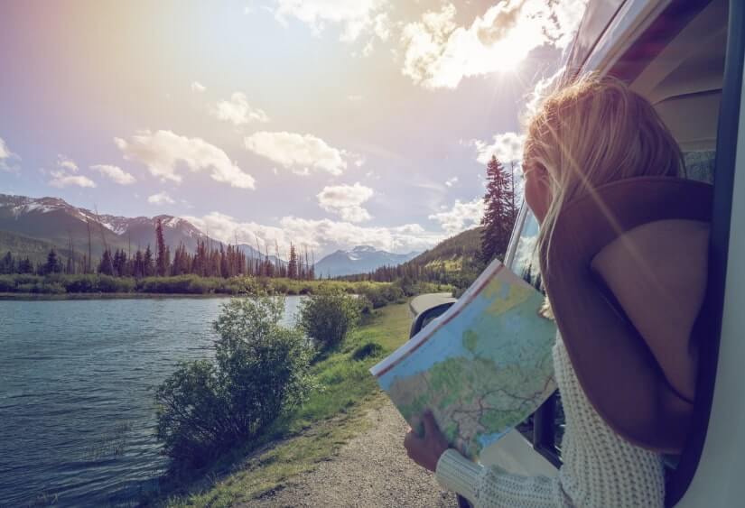 traveller enjoying the view of a lake through the window