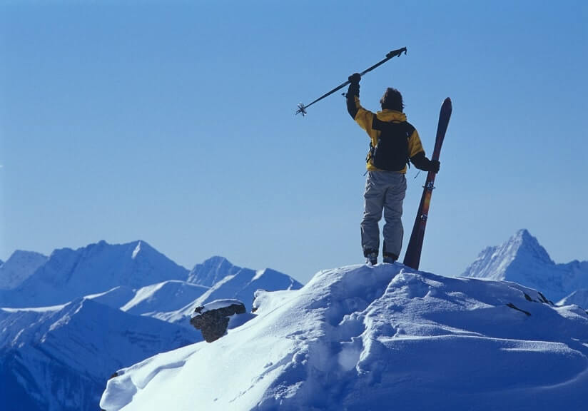 une femme tenant son matériel de ski