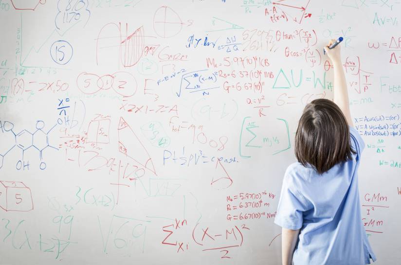  un niño escribiendo en una pizarra blanca